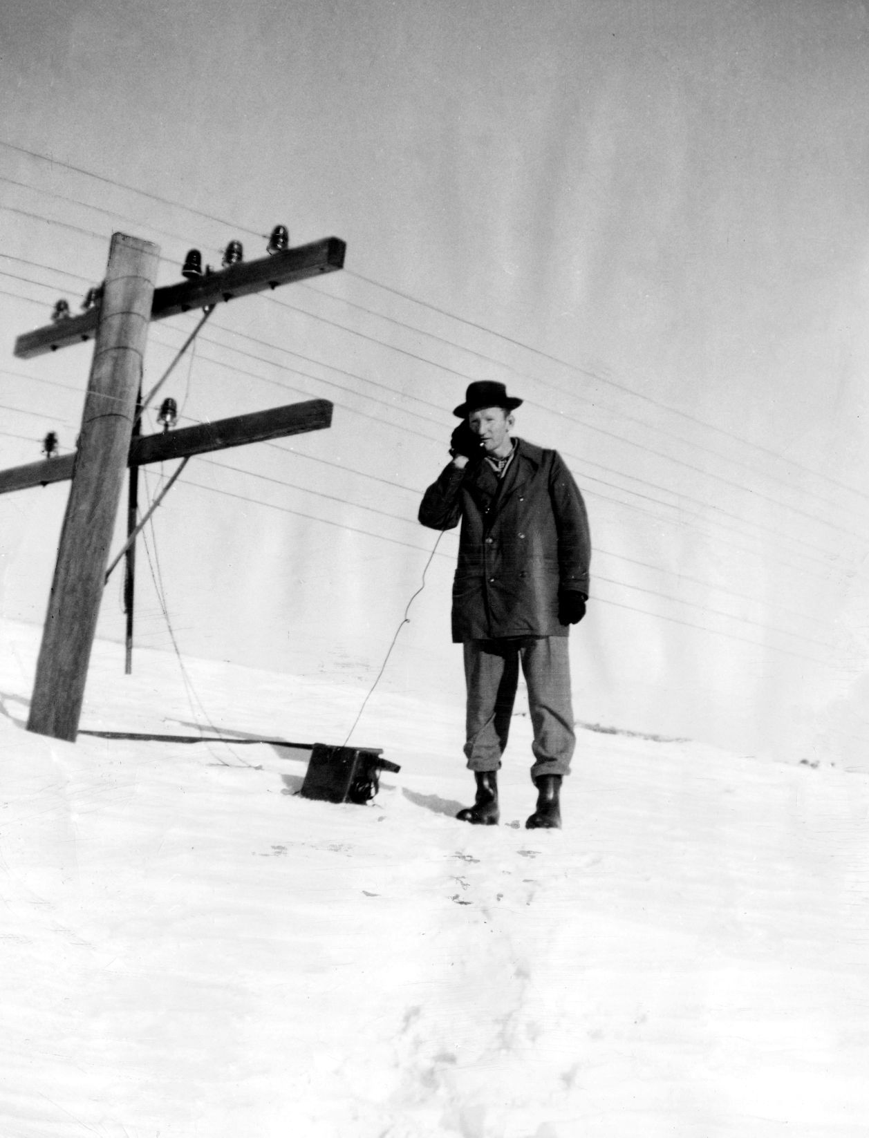 J.J. Ganney of Ashby, an agent-operator for the Burlington, stands on top a 10-foot drift talking over a portable telephone to report a cave-in to the division office.